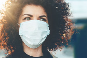Eine Frau trägt eine medizinische Maske.