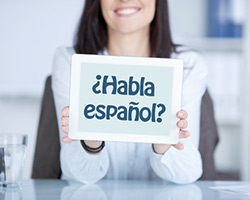Einkommensteuer - Junge Frau hält Schild mit Aufschrift habla espanol