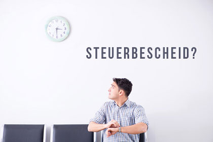 Fehlerhafte Übermittlung der vermögenswirksamen Leistungen Ein Mann schaut ungeduldig auf eine Uhr an der Wand. An der Wand steht „Steuerbescheid?“