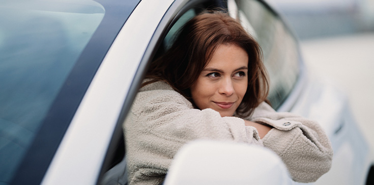 Junge Frau sitzt am Steuer ihres Autos