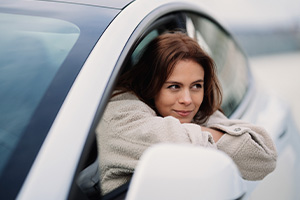 Junge Frau sitzt am Steuer ihres Autos