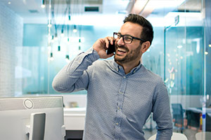 Fröhlicher Angestellter telefoniert im Büro