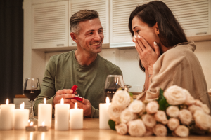  Ein Mannes, der seiner Freundin bei einem romantischen Abendessen einen Heiratsantrag macht.