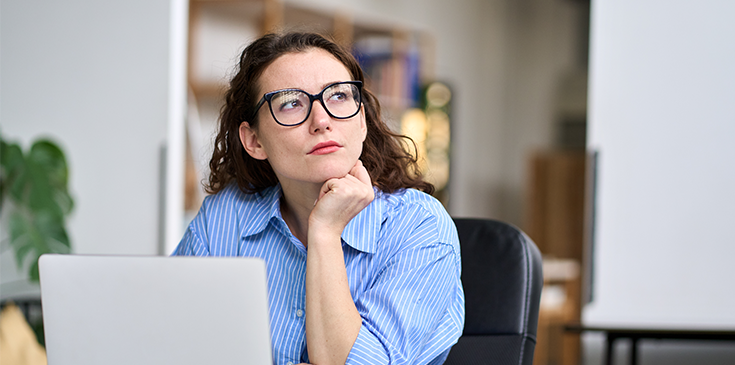 Welche Daten speichert das Finanzamt über mich? Nachdenkliche Frau mit Brille am Laptop – sie fragt sich, was das Finanzamt über sie weiß. Der Steuerring hilft bei Fragen rund um das Thema.