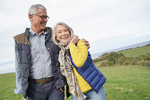 Riester-Rente, Rürup-Rente: Zulagen und Steuervorteile zum Jahresende sichern Ein älteres Paar steht im Freien, lächelt und umarmt sich liebevoll. Beide tragen warme Kleidung und wirken glücklich.