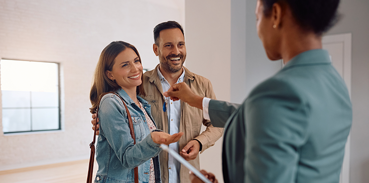 Eine Maklerin überreicht einem jungen Paar den Schlüssel zu ihrer neuen Wohnung. Dank des Steuerrings wissen sie genau, welche Kosten sie jetzt steuerlich absetzen können.