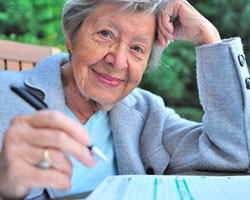 Eine ältere Frau füllt ein Formular aus