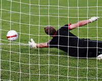 Fußballer im Tor nach einem Ball greifend