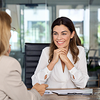 Zwei Frauen sitzen sich in einem modernen Büro gegenüber und sprechen über die Entlastungsprämie.
