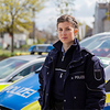 Eine junge Polizistin steht vor einem Auto. Dank der Unterstützung durch das Unternehmen Steuerring kennt sie ihre steuerlichen Vorteile.