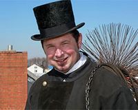 Schornsteinfeger als Handwerkerleistung ansetzen Ein Schornsteinfeger auf dem Dach