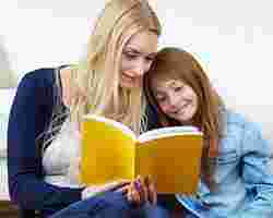 Eine junge Frau schaut mit einem Kind ein Buch an.