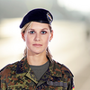Eine Soldatin blickt gerade in die Kamera. Sie trägt eine Uniform.