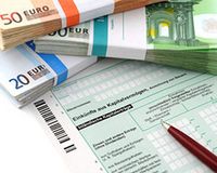 Geldscheine liegen auf dem Steuererklärungsformular für Einkünfte aus Kapitalvermögen.