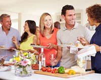 Feiern und Steuern sparen Fünf Erwachsene unterhalten sich am Buffet