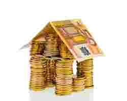 Immobilien-Darlehen: Ein Haus aus Münzen und Geldscheinen
