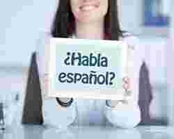 Einkommensteuer - Junge Frau hält Schild mit Aufschrift habla espanol