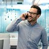 Fröhlicher Angestellter telefoniert im Büro