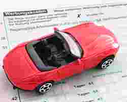 Ein Spielzeugauto auf einem Einkommensteuererklärungs-Formular