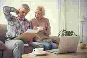 Rentner-Ehepaar blickt verwirrt auf ein Papier
