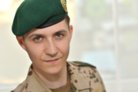 Ein Soldat blickt gerade aus in die Kamera.