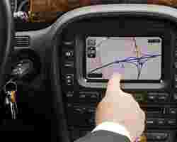 Finger zeigt auf Navigationsgerät im Auto