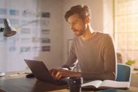 Steuererklärungspflicht für Geflüchtete aus der Ukraine Ein Mann mittleren Alters sitzt mit leicht gerunzelter Stirn vor seinem Laptop.