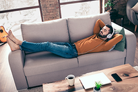 Fristverlängerung: So beantragen Sie mehr Zeit für die Steuererklärung Ein Mann liegt entspannt mit einem Laptop auf dem Sofa – sichtbar erleichtert, weil er dank des Steuerrings von der Möglichkeit einer Fristverlängerung wusste.