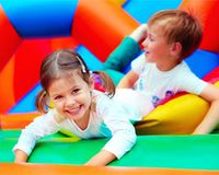 Kinderbetreuungskosten: Kürzung um Arbeitgeber-Zuschüsse Ein Junge und ein Mädchen spielen auf einer Hüpfburg.